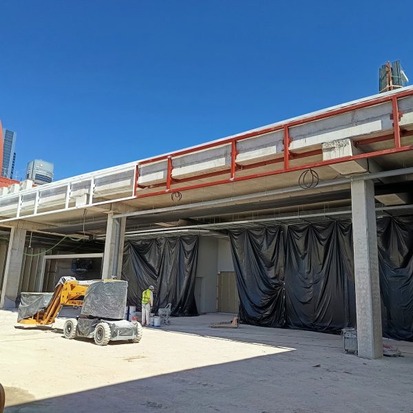 Marquesina de estructura metálica con imprimación roja y lonas de protección en la estación de Chamartín